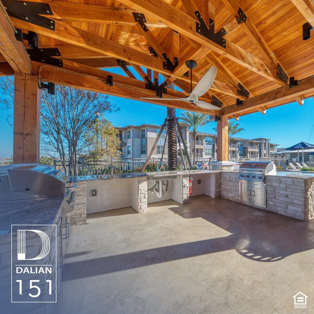 The outdoor grill area at Dalian 151, equipped with modern grilling facilities, seating arrangements, and surrounded by lush landscaping, offering residents a perfect spot for outdoor gatherings and BBQs