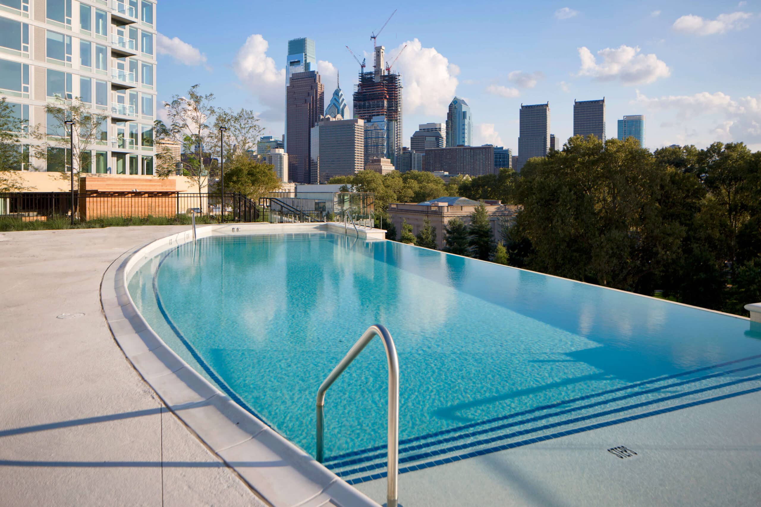 The pool area at Dalian On The Park, featuring a sparkling pool, and lush landscaping, providing residents with a refreshing and relaxing outdoor retreat