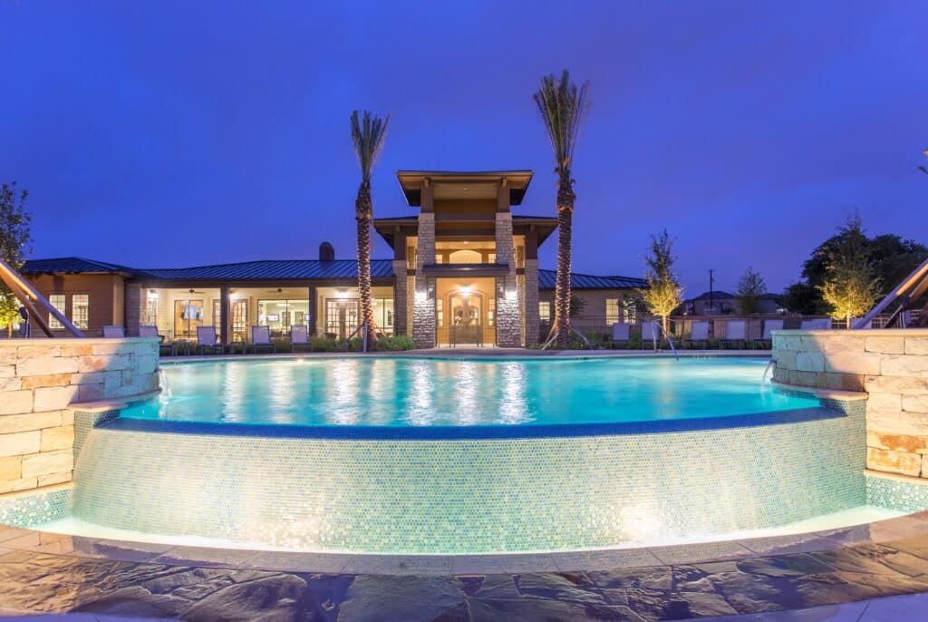 A nighttime view of the pool at Monterrey Village, illuminated by soft lighting, creating a tranquil and inviting atmosphere for residents to enjoy